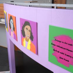 Knallige Anne Frank Portraits und Zitate haengen an der Wand.JPG
